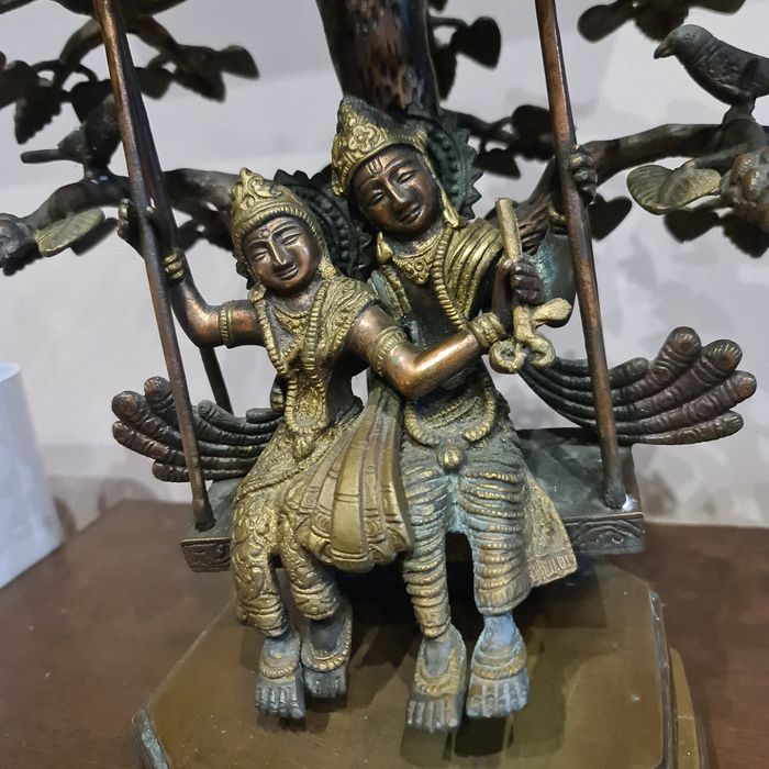 Statuie Radha Krishna alamă leagănându-se sub un copac împodobit