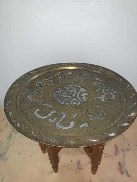 Masuta arabeasca cu blat alama gravata asezata pe suport de lemn