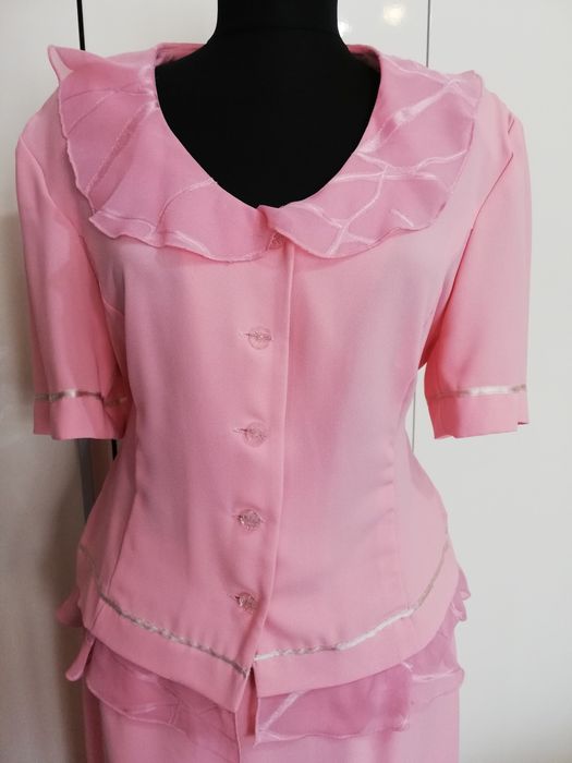 Costum cu fustă. Bluzița are nasturi.