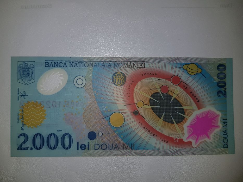 Bancnota 2000 lei cu eclipsa de soare și moneda 500 lei.