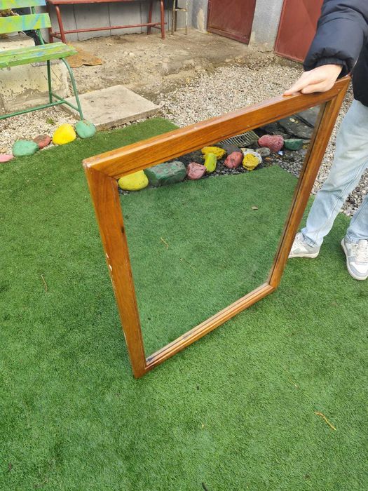 Oglinda cu ramă din lemn masiv.