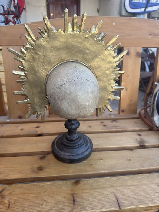 Craniu decorativ sculptata pe stativ cu coroană aurie detaliată