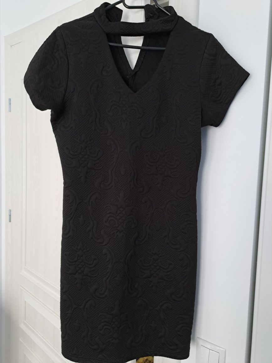 Rochie neagra cu fermoar pe spate.