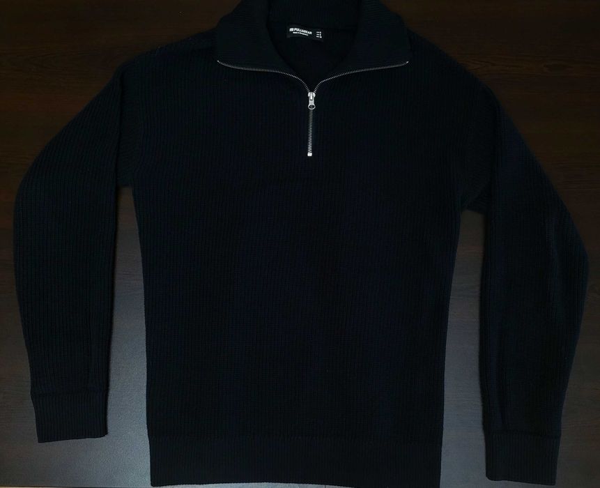 Плетен пуловер с четвърт цип и дълги ръкави.