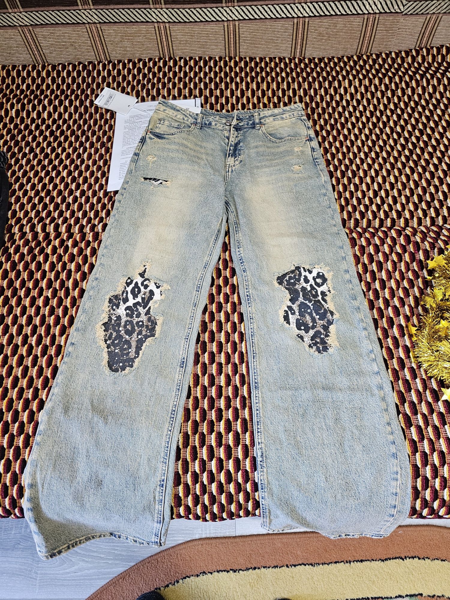 Blugi din denim de un albastru uzat cu rupturi  și animal print