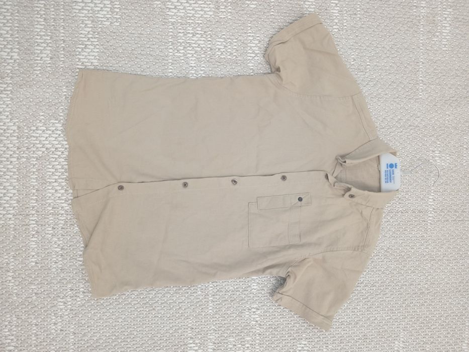 Бежевая рубашка с коротким рукавом.