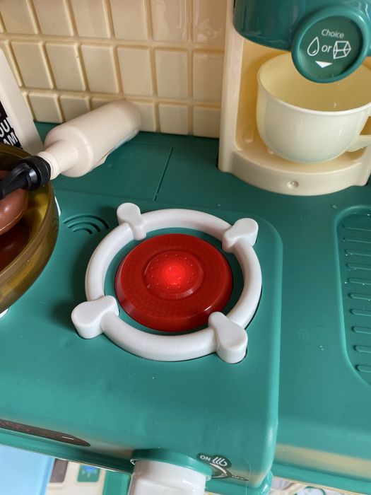 Кухня със светещи котлони, пара и мивка с течаща вода