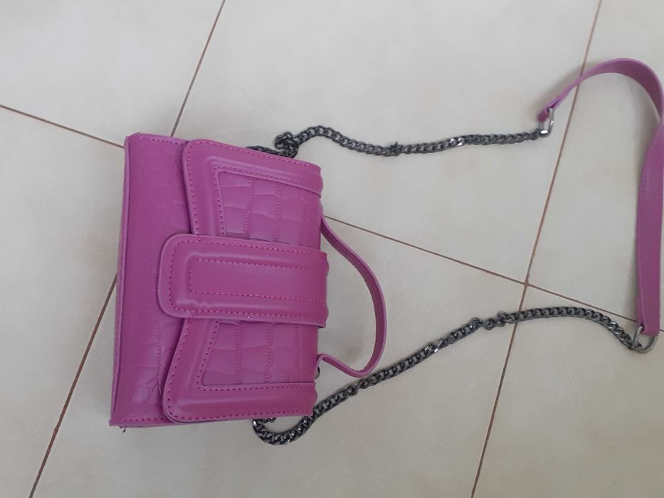 Дамска кожена чанта в много нежен лилав цвят и дълга дръжка.