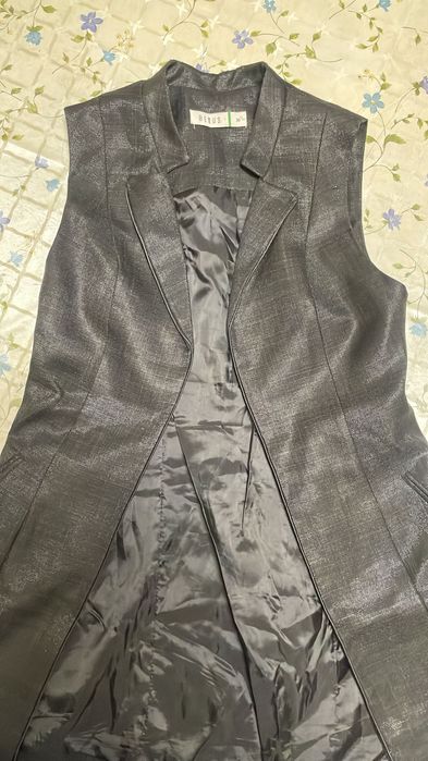 Чёрный женский костюм из блестящей ткани, безрукавки и брюк.