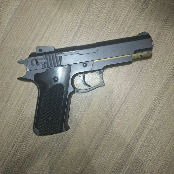 Игрушечный пистолет с пружинно спусковой конструкцией