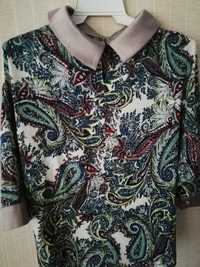 Лёгкая нарядная блузка из полиэстера с цветным принтом.