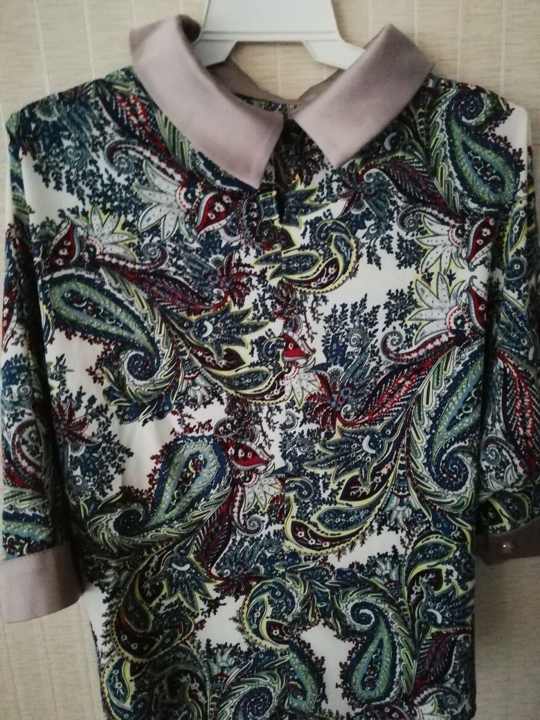 Лёгкая нарядная блузка из полиэстера с цветным принтом.