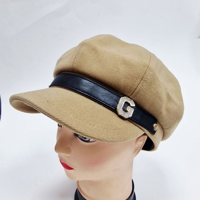 Елегантна дамска шапка тип фуражка с декоративна лента и метално лого.