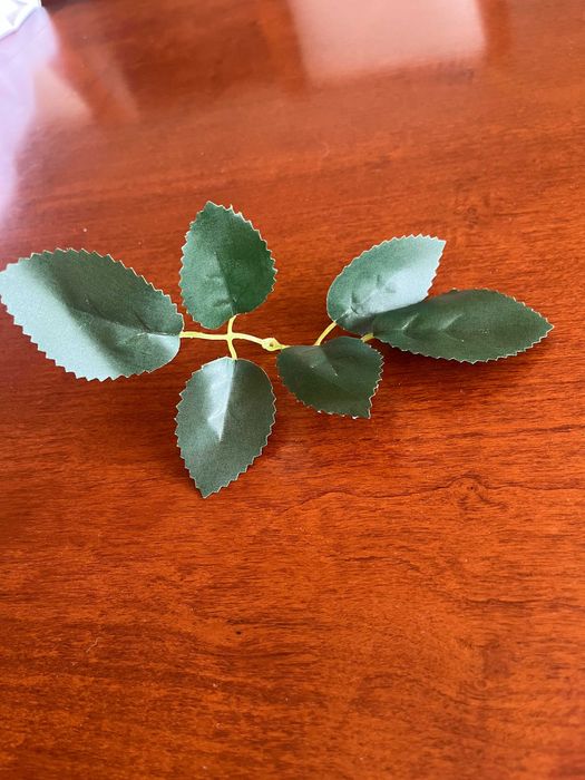 Бяла метална арка с червени рози и друга сватбена украса