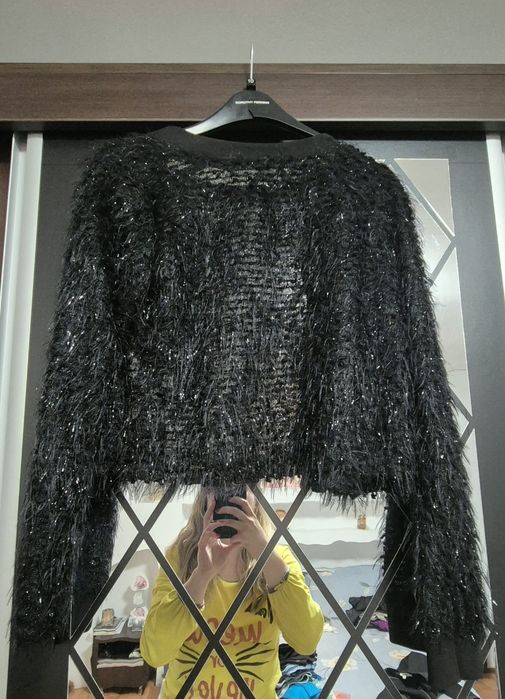 Jachetă bolero neagră, cu o aplicație florală.