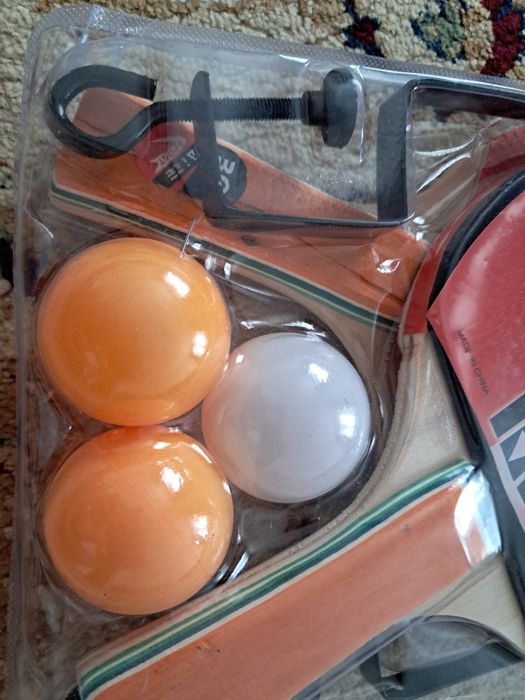 Ракетки, шарики и сетка для игры в теннис..