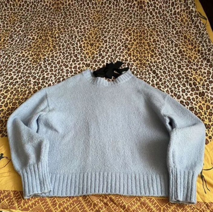 Свитер голубого цвета сзади есть завязка
