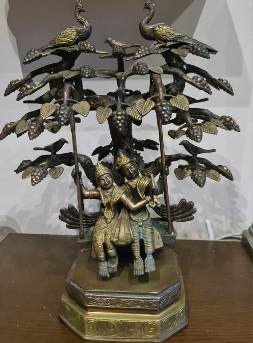 Statuie Radha Krishna alamă leagănându-se sub un copac împodobit