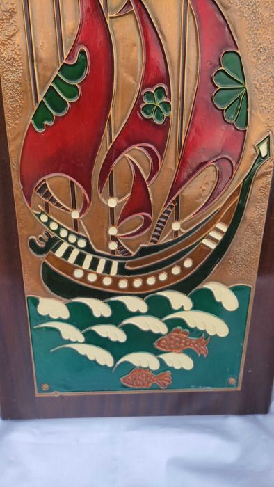 Голяма цветна медна пластика върху дървена основа