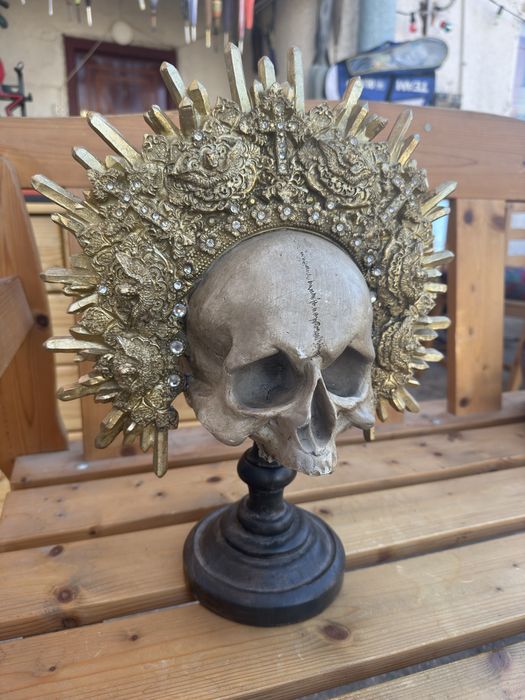 Craniu decorativ sculptata pe stativ cu coroană aurie detaliată