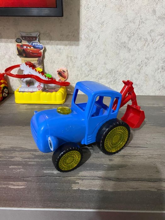 Продам синий трактор с красным ковшом .