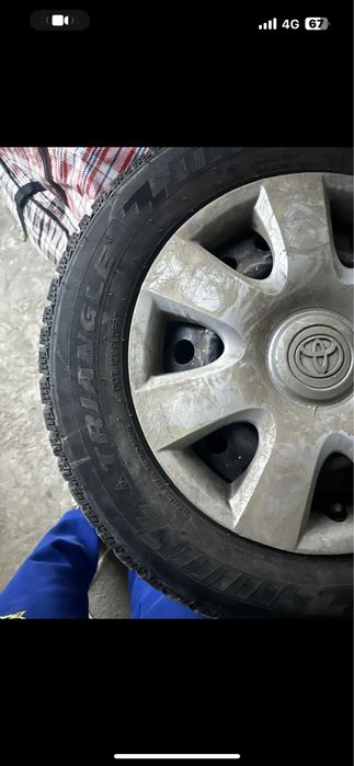 Зимние шипованные шины на железных дисках с калпаками оригинал.