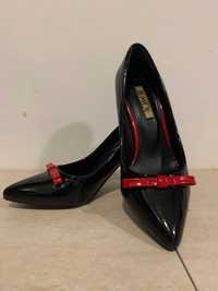 Много елегантни дамски обувки с червена панделка и висок ток