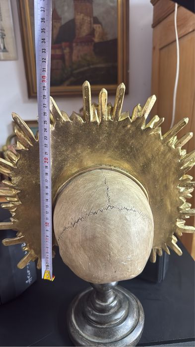 Craniu decorativ sculptata pe stativ cu coroană aurie detaliată