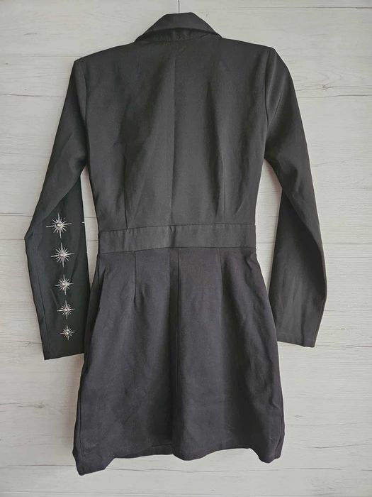 Елегантна черна рокля с декоративни елементи.