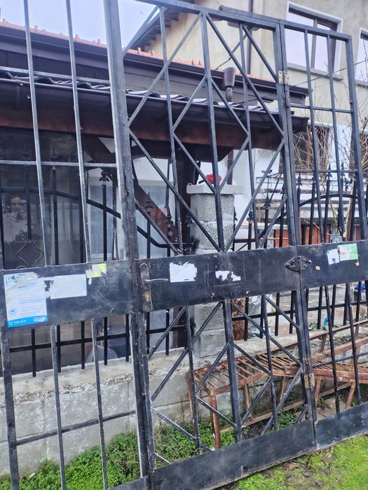 Голяма метална външна врата с две решетки. Много висока