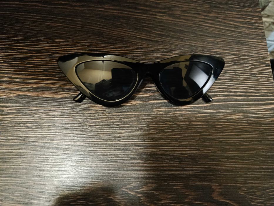 Черни очила с триъгълна форма.