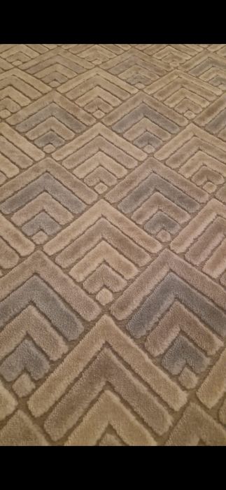 Covor cu motive  dungate si culori calde.