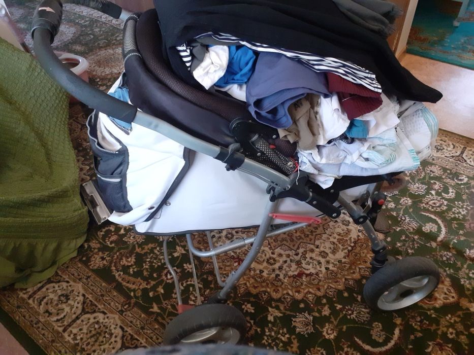 Продам кроватку детскую с люлькой.  Коляску. Ванночку. И комбинезон.