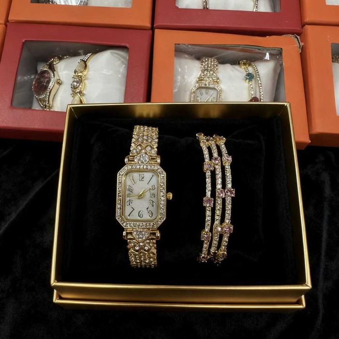 Луксозен дамски комплект: часовник и гривни в златист цвят.