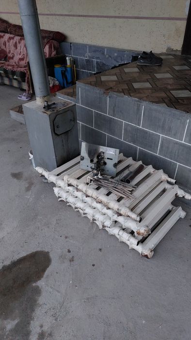 Отопление, газовый котёл, чугунные батареи и труба с дефлектором