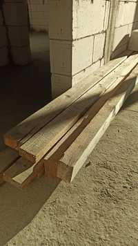 Vand grinzi de lemn rămase după o constructie