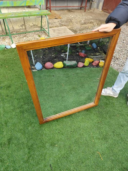 Oglinda cu ramă din lemn masiv.