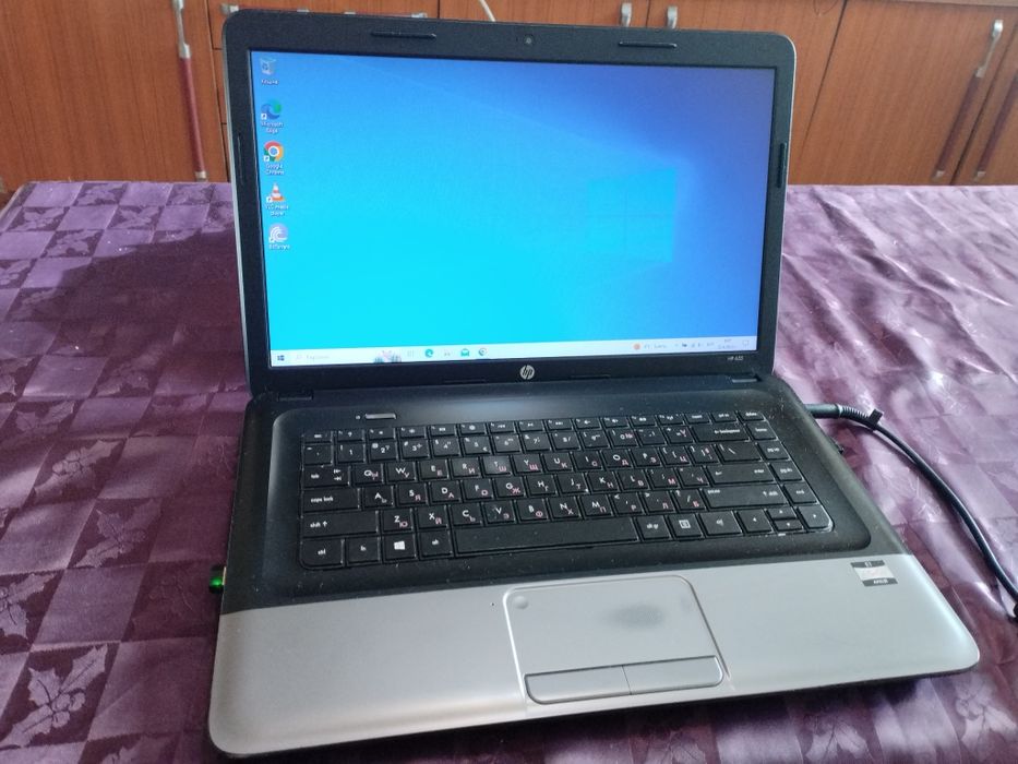 Намален лаптоп HP с Windows 10 Home и зарядно устройство.