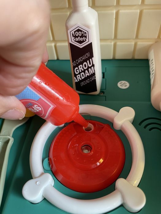 Кухня със светещи котлони, пара и мивка с течаща вода