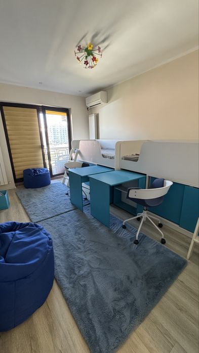 2 paturi identice cu birouri, scaune, spații de depozitare, saltele