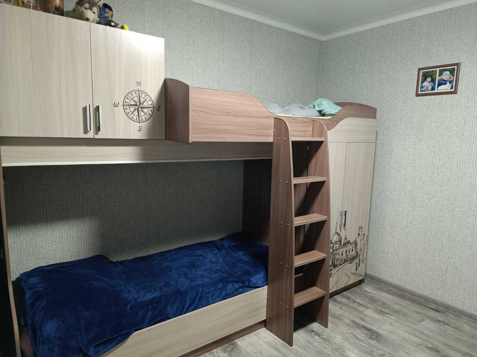 Двух ярусная кровать со встроенным платяным шкафом и полкой.