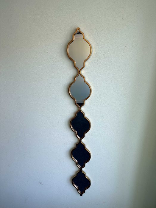 Oglinda decorativa suspendata pe perete