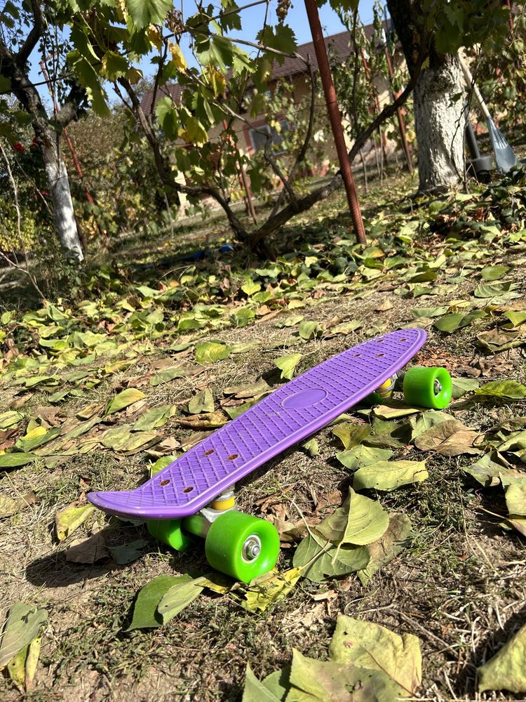 Penny board cu placa mov si roti verzi