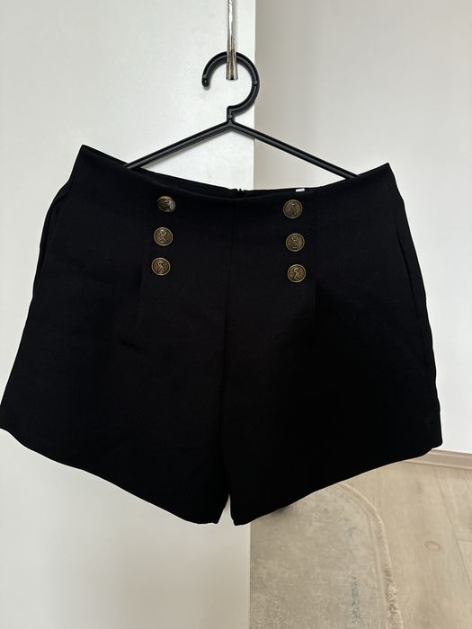 Стильные чёрные вечерние шорты с золотыми пуговицами,создающие образ..
