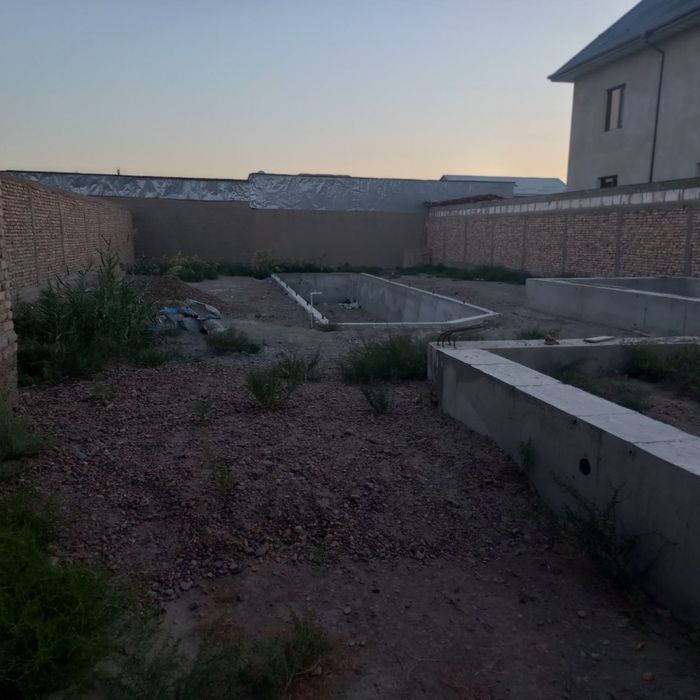 Курилиши тугалланмаган турт томони ураб олинган участка