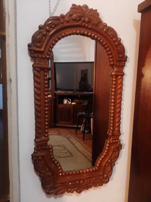 Oglinda cu rama din lemn.