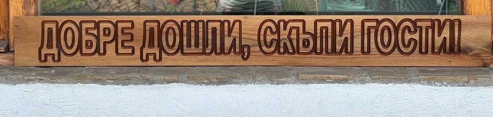 Масивна дървена табела с надпис "Добре дошли, скъпи гости!"
