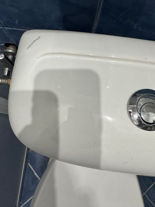 Мивка за баня с шкафче и тоалетна чиния .