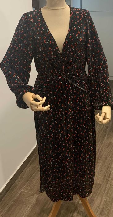 Rochie neagra cu maneci lungi din material raiat.