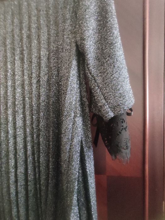 Блузон с дантела на ръкава .Бульона е на плисе в черен цвят с лъскави